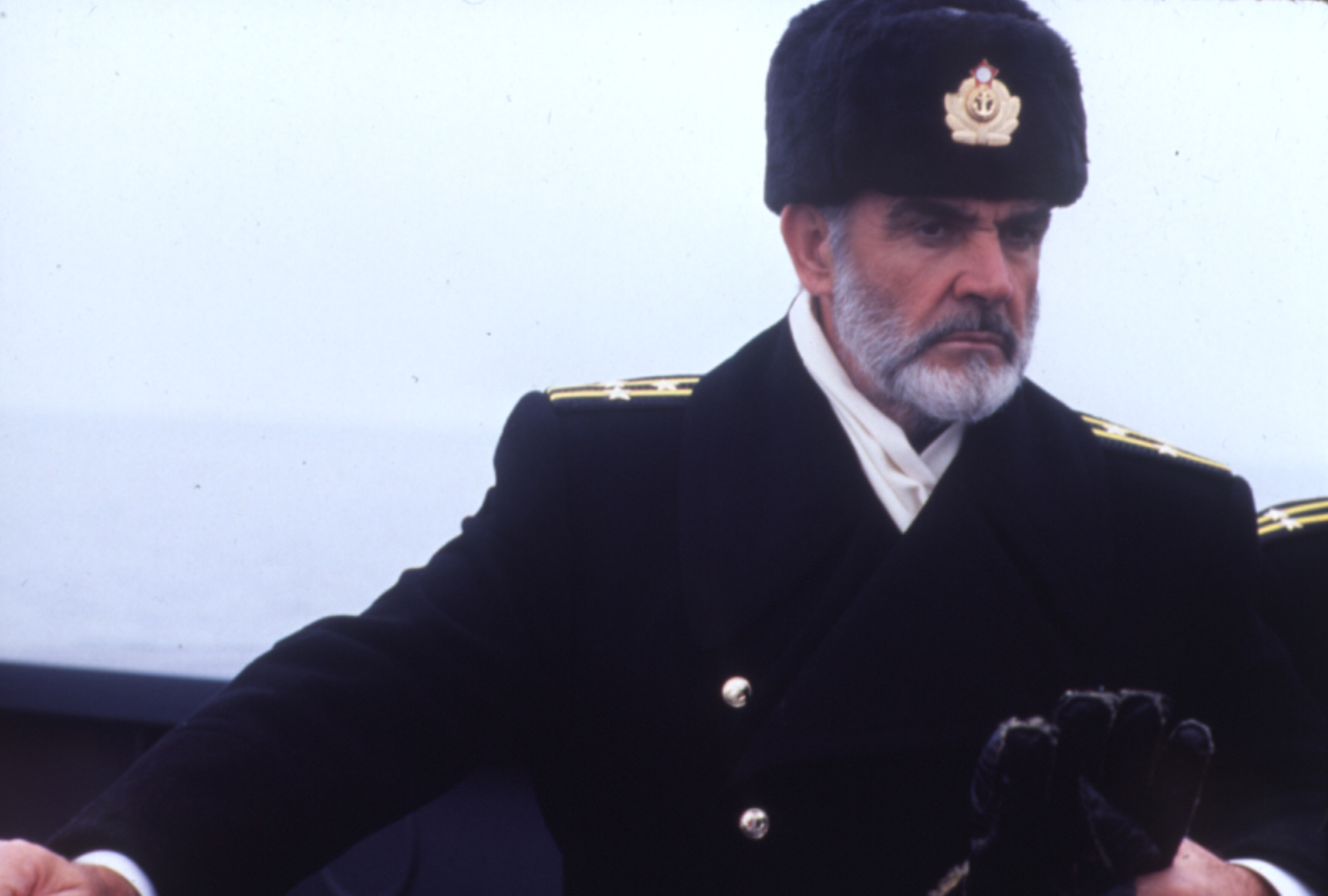 Ein Mann (Kapitän) in russischer Marinewinteruniform mit Pelzmütze blickt nachdenklick.