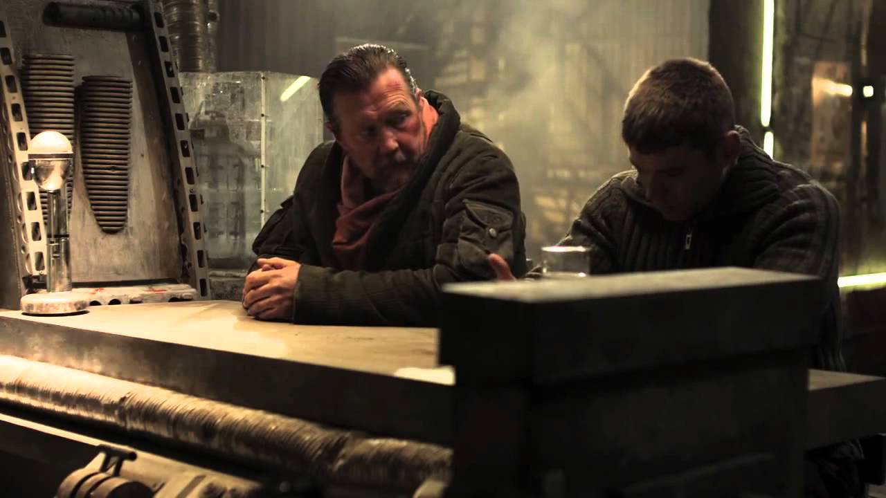 Ein alter und ein junger Mann sitzen an einer Bar und unterhalten sich.